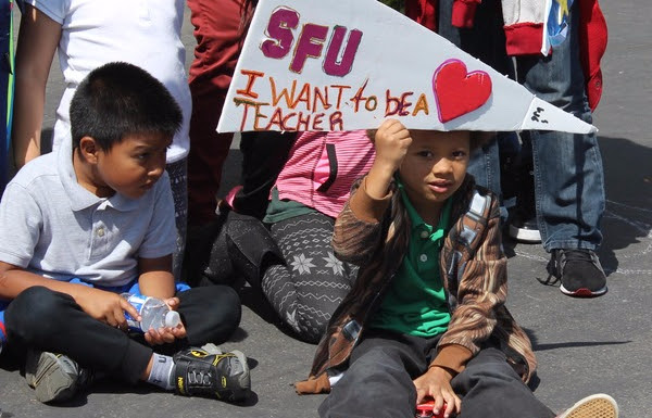 Mission Graduates student holding sign for SFU saying I want to be a teacher